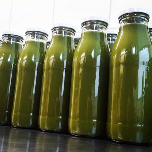 Grüner Saft von Pressgut in Flaschen