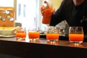 Orangener Saft von Pressgut in Gläsern